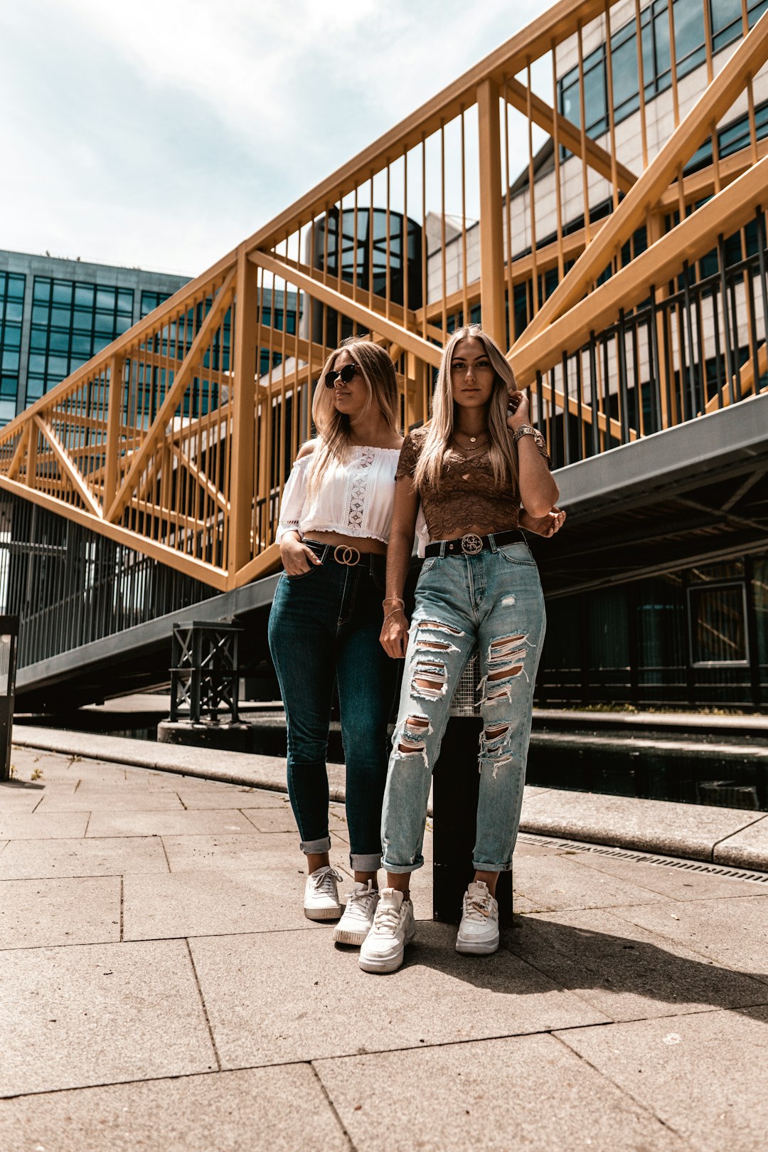 2 women standing on gray concrete floor during daytime