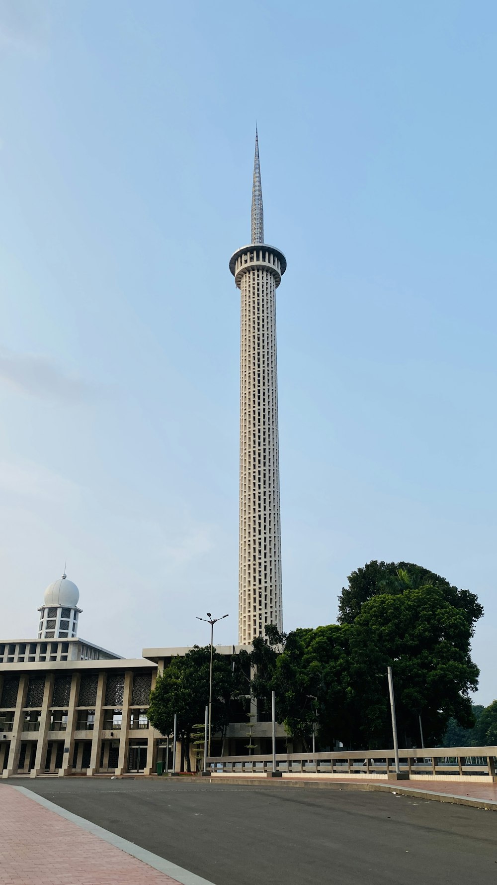 white concrete tower near green trees during daytime