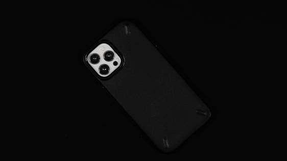 A smartphone with a prominent camera module featuring three lenses against a dark background.