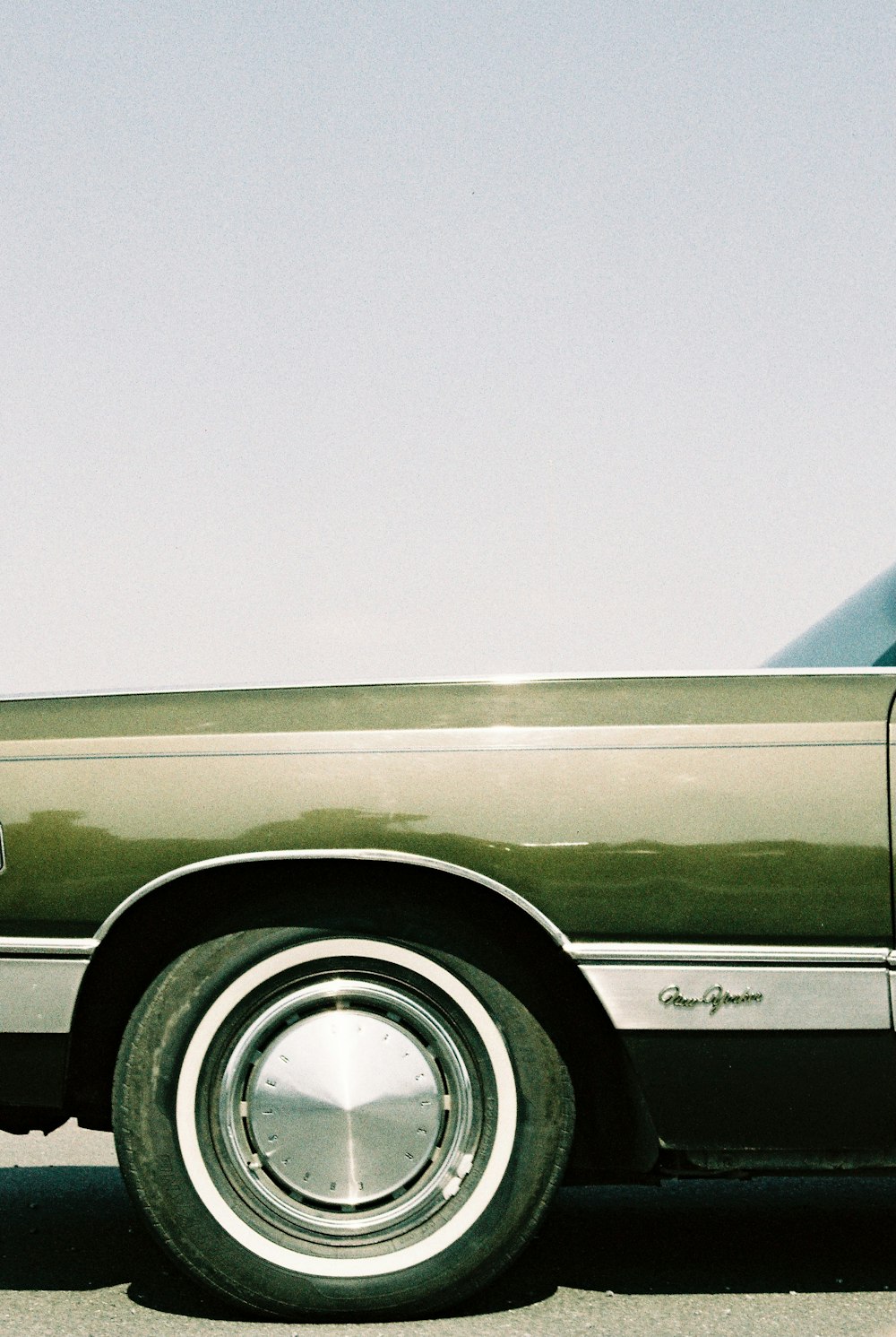 green car under white sky during daytime