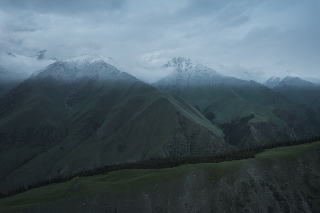 green and white mountains under white clouds during daytime