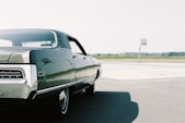 black sedan on gray asphalt road during daytime
