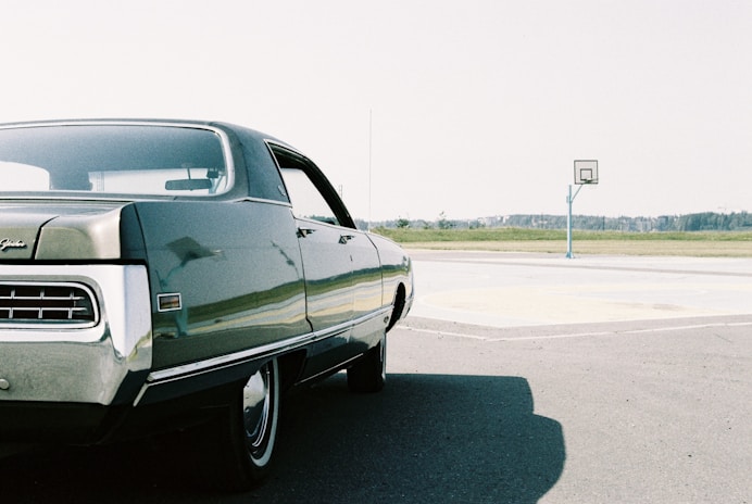black sedan on gray asphalt road during daytime