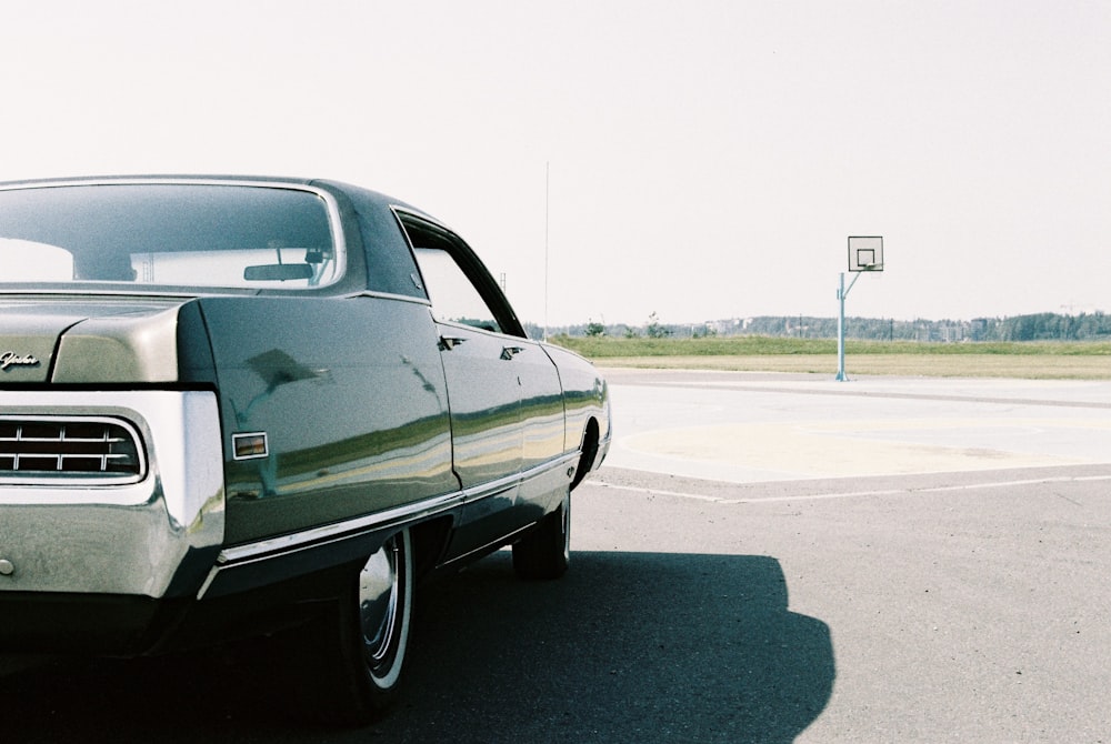 black sedan on gray asphalt road during daytime