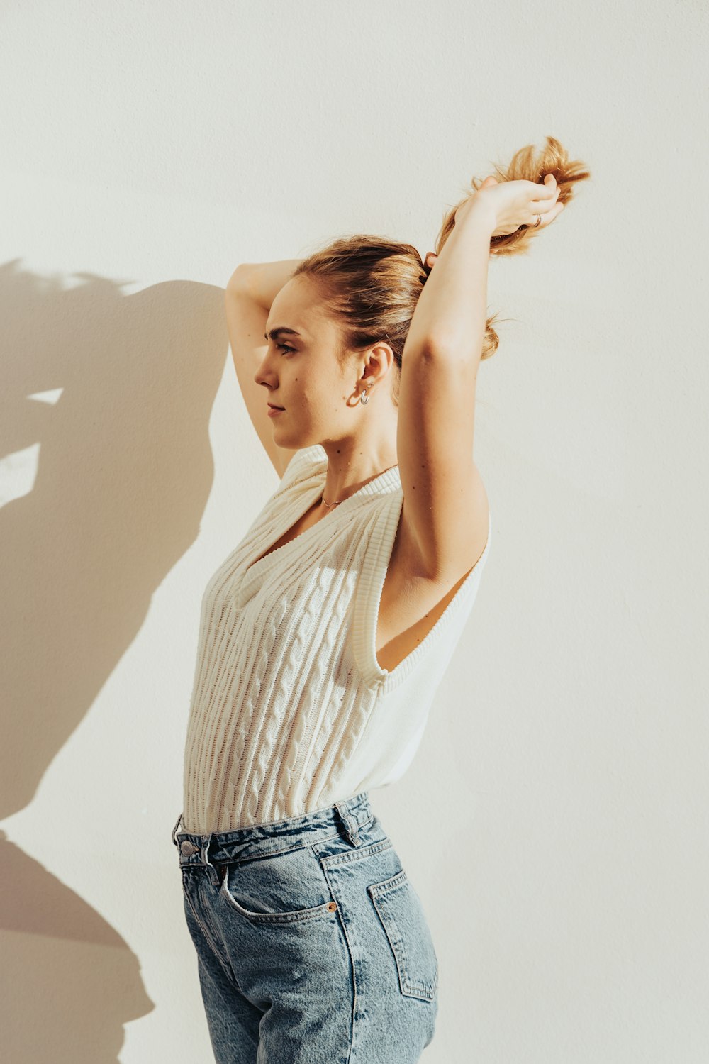 woman in white and gray striped tank top and blue denim jeans