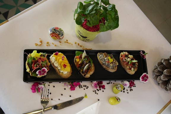 A clean, modern plate with colorful bruschetta topped with fresh tomatoes and basil on a rustic wooden table.