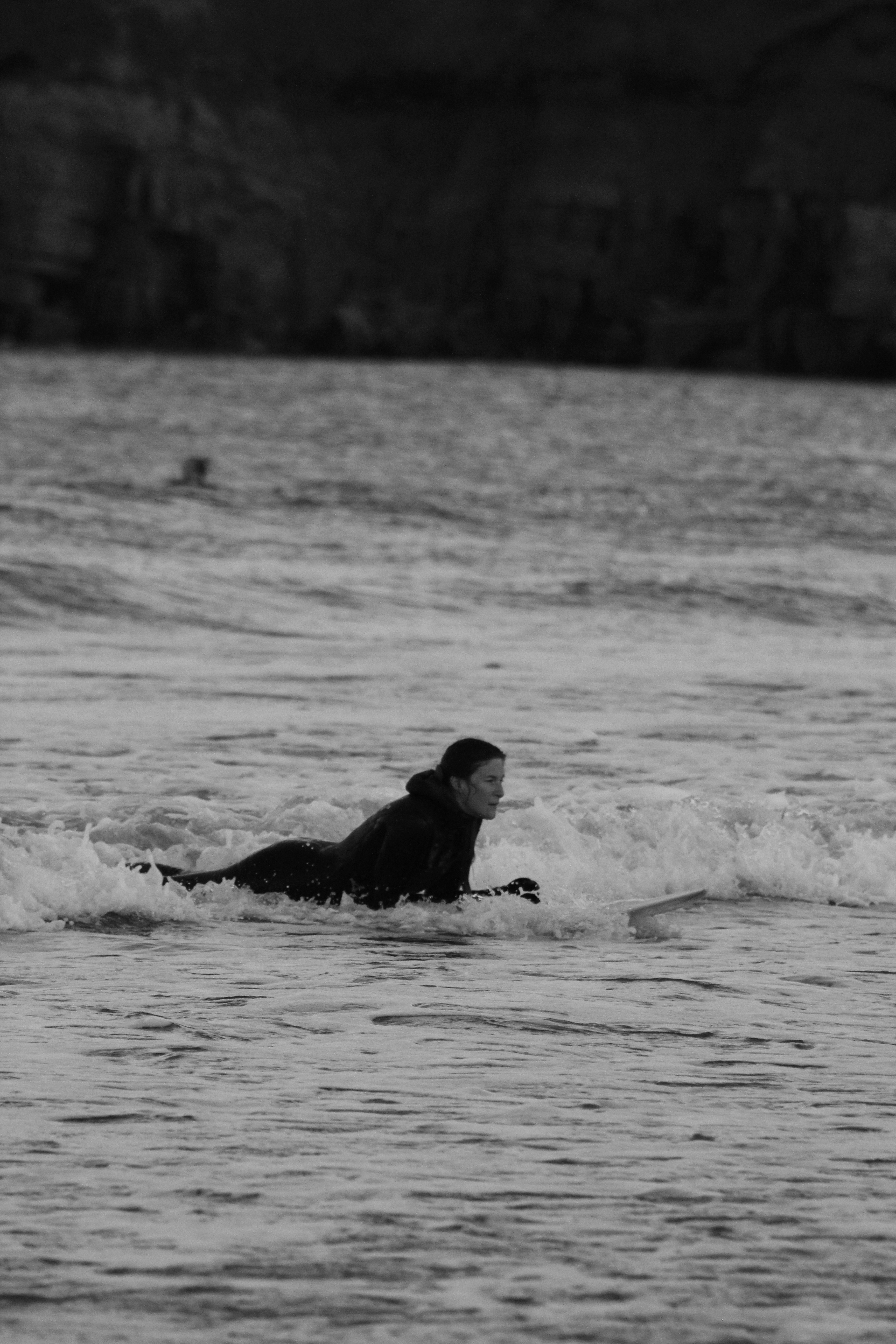 man in black wet suit lying on water during daytime