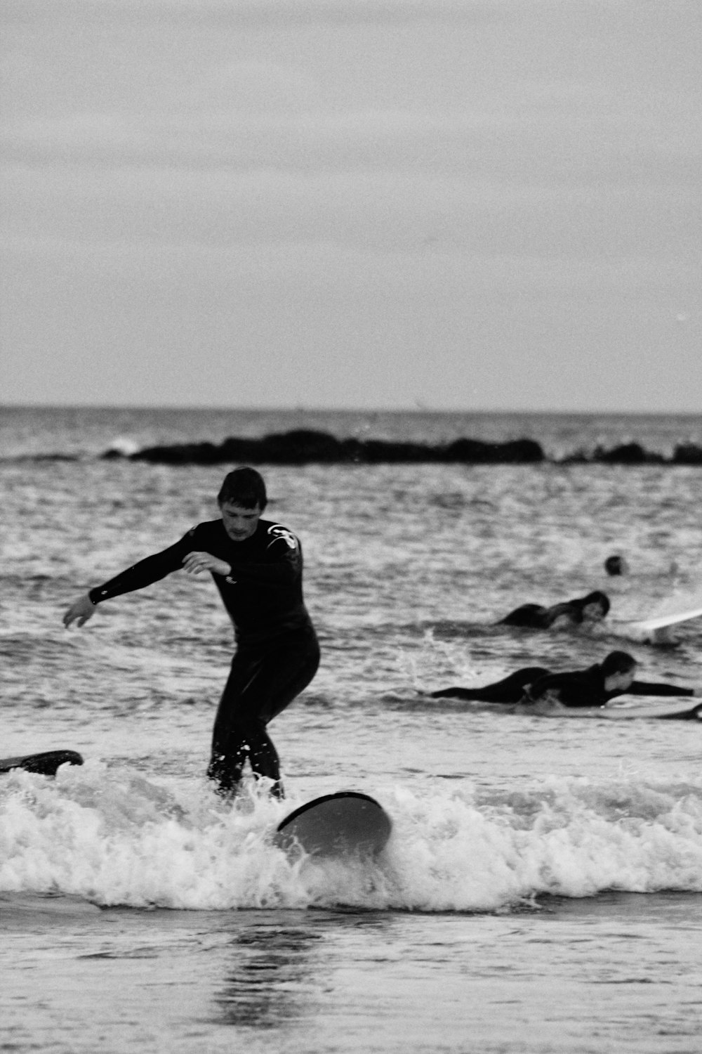 man in black wet suit playing on the beach