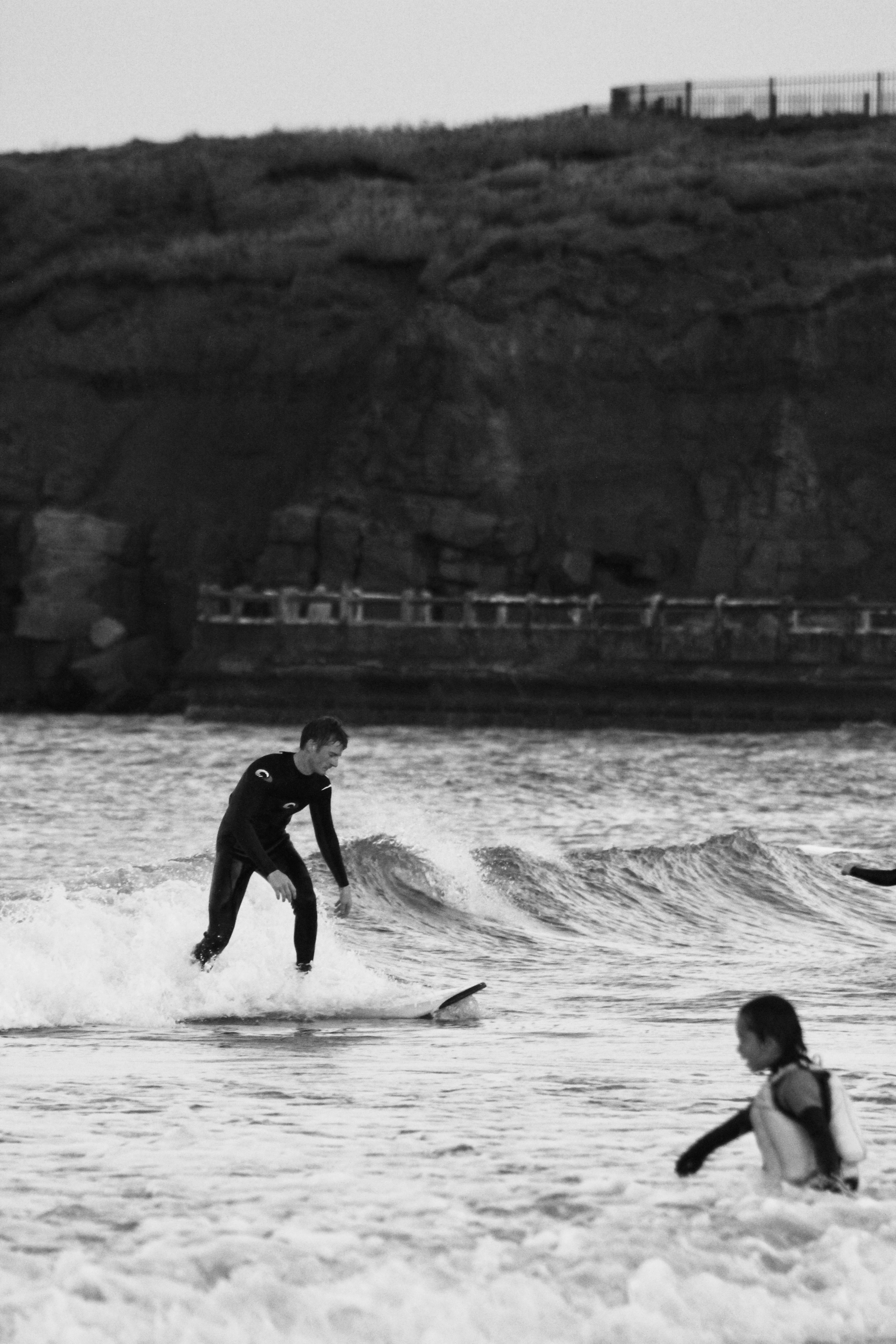 grayscale photo of 2 boys playing on sea