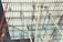 Workers are perched atop a complex network of scaffolding beams under a bright sky, engaging in construction or maintenance tasks.