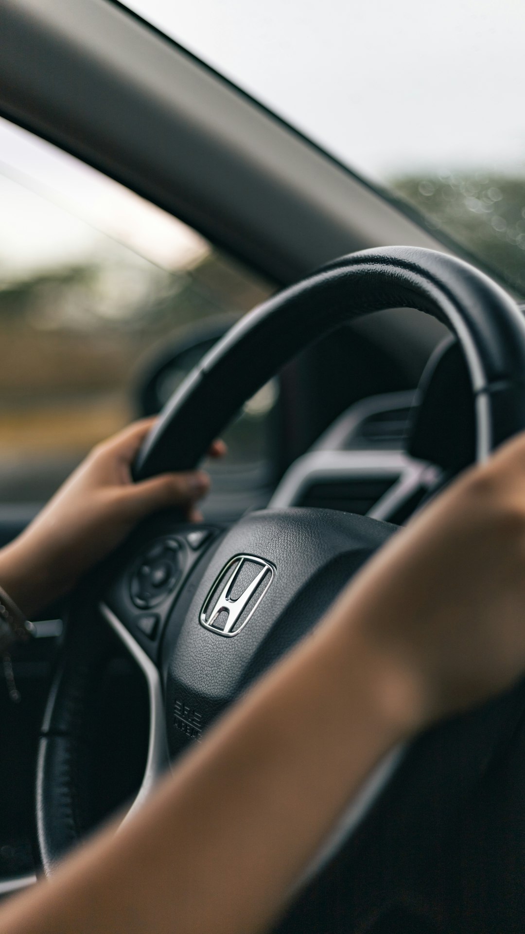 person driving black honda car during daytime