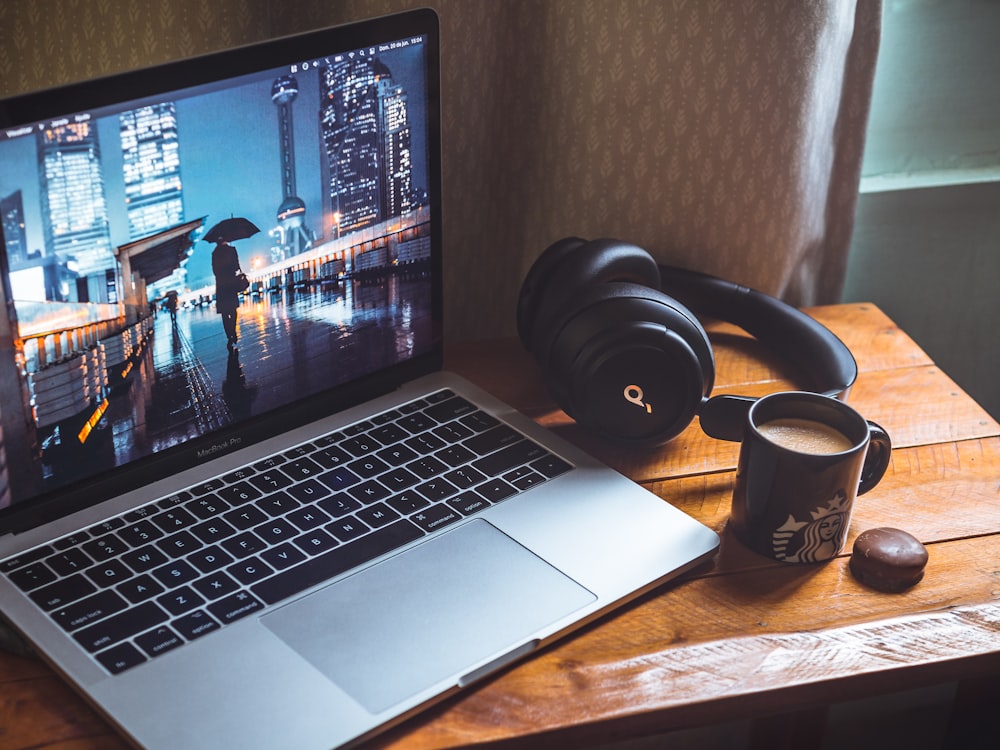 macbook pro beside black headphones