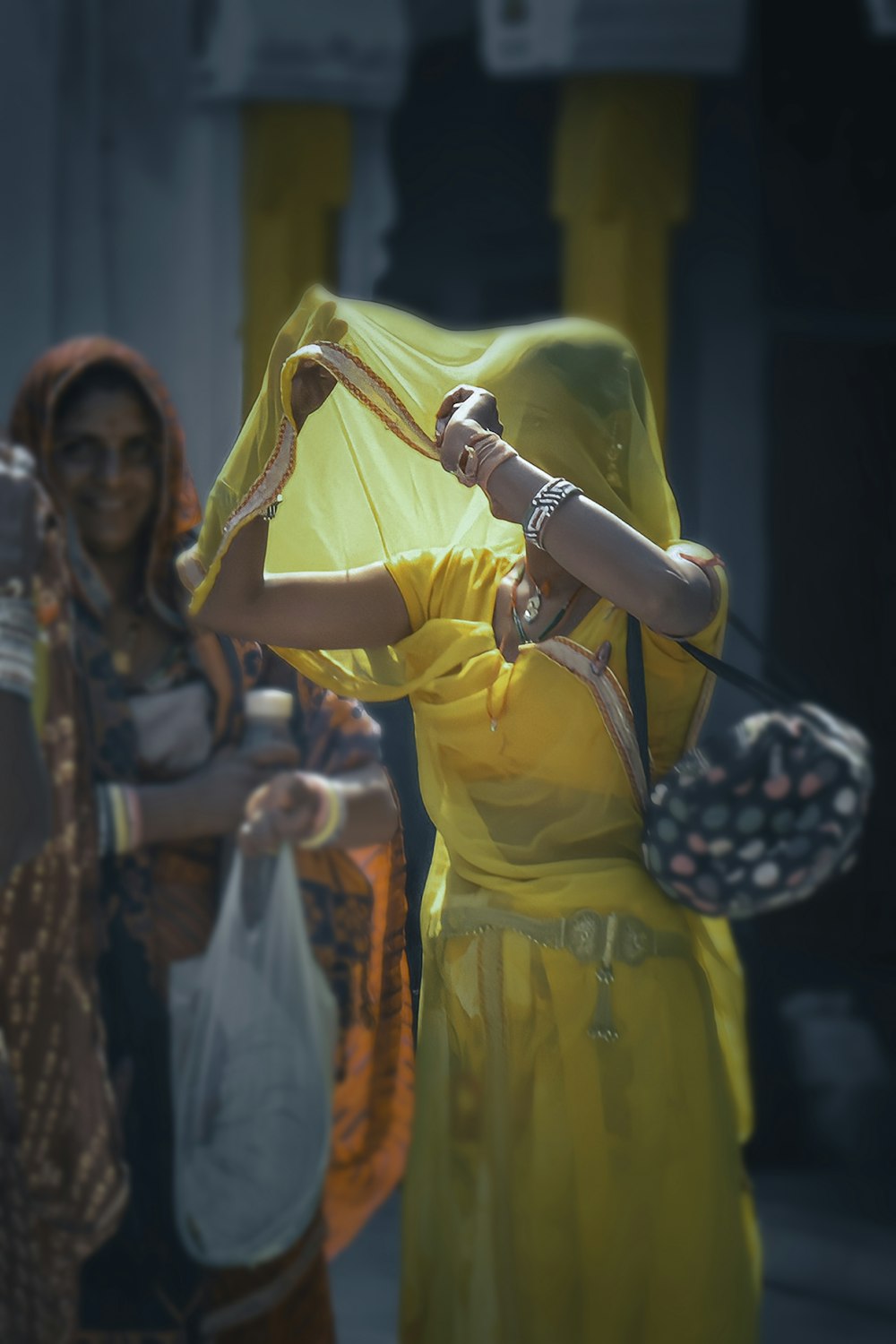 woman in yellow dress standing beside woman in black and white polka dot dress