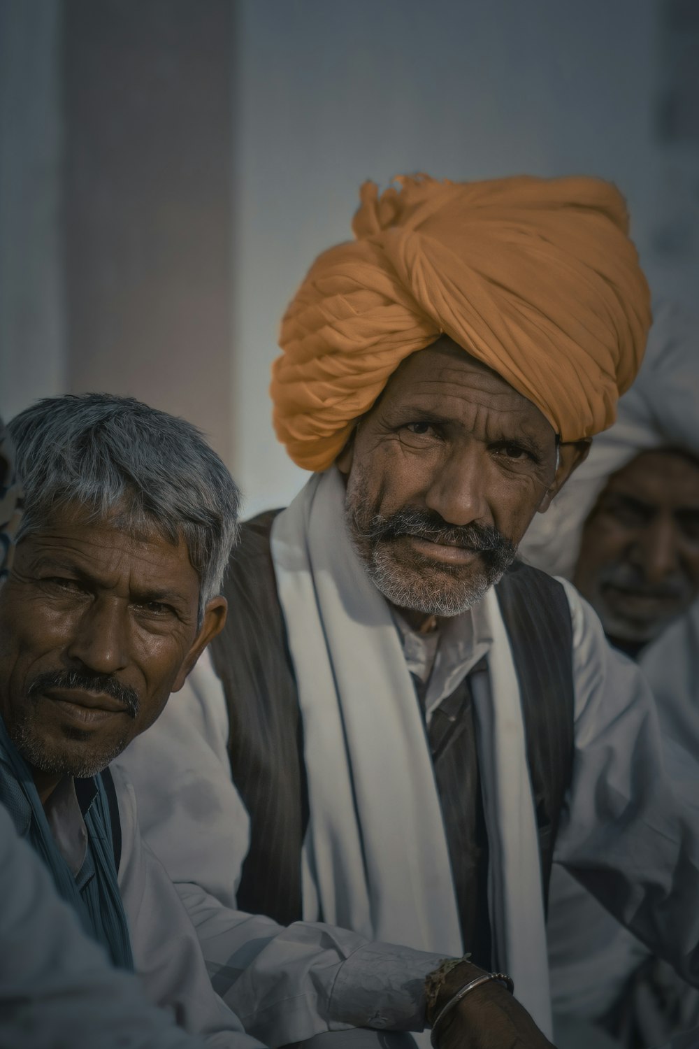 man in white dress shirt and orange turban