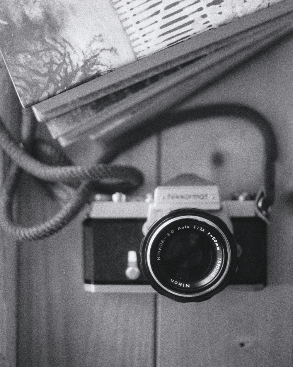 grayscale photo of a camera on a book