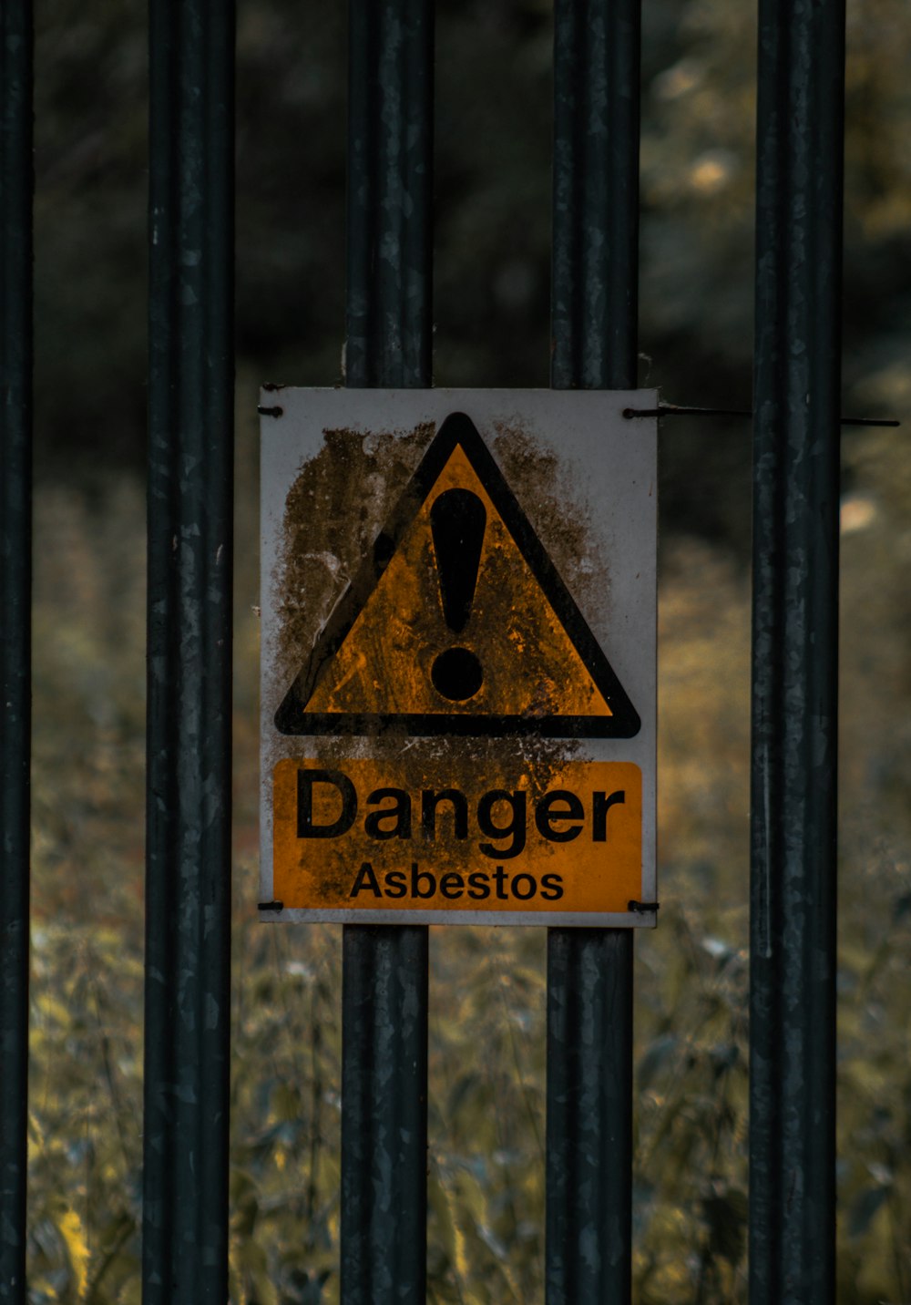 un cartello su una recinzione metallica che avverte di pericolo