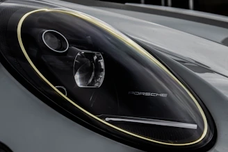 Close-up of a sleek Porsche with a newly installed aggressive front bumper and LED headlights.