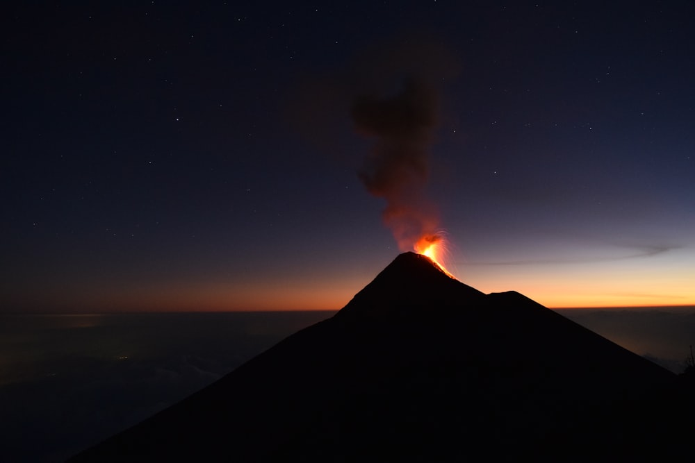 silhouette of mountain under blue sky during night time