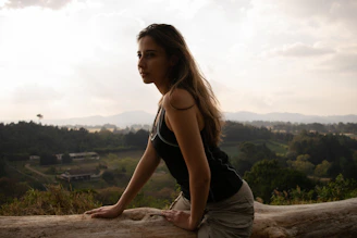 A serene woman sitting peacefully in nature, reflecting on her personal transformation journey.
