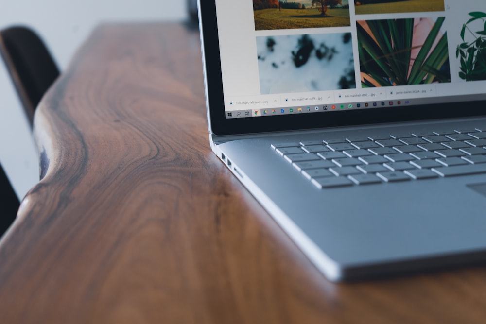 black and silver laptop computer on brown wooden table