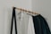Close-up of a woman’s hand holding a minimalist capsule wardrobe clothing rack.