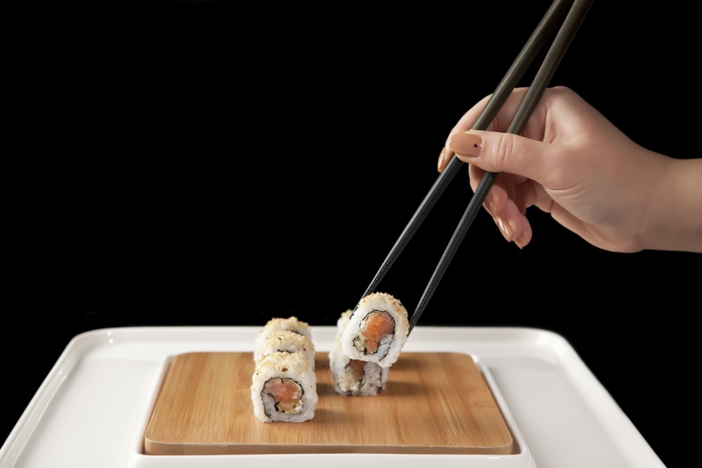 person holding chopsticks and bread