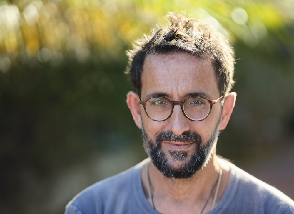 man in blue crew neck shirt wearing black framed eyeglasses