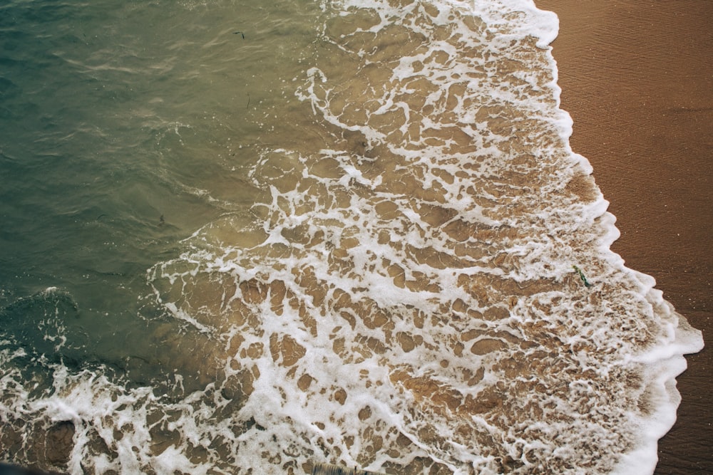 ocean waves crashing on shore during daytime