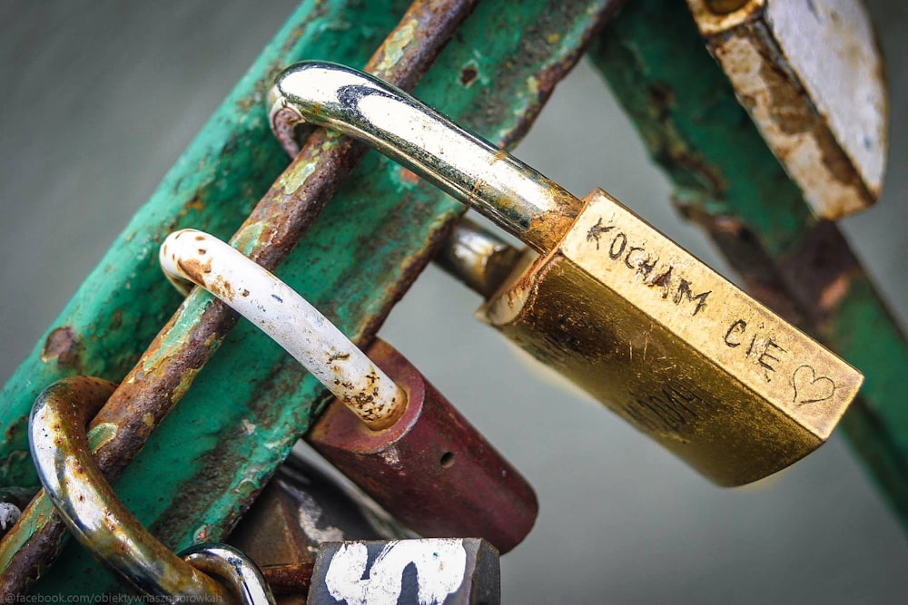 brass padlock on green metal bar