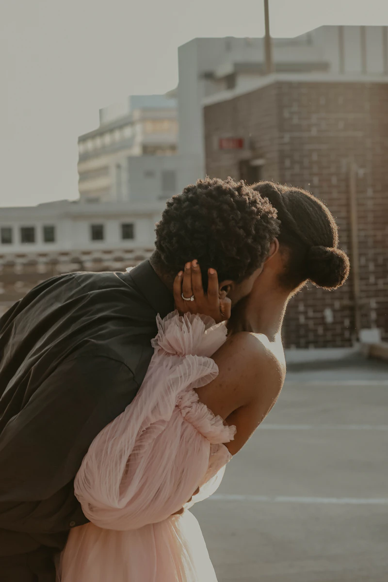 Couple kissing on a rooftop at sunset