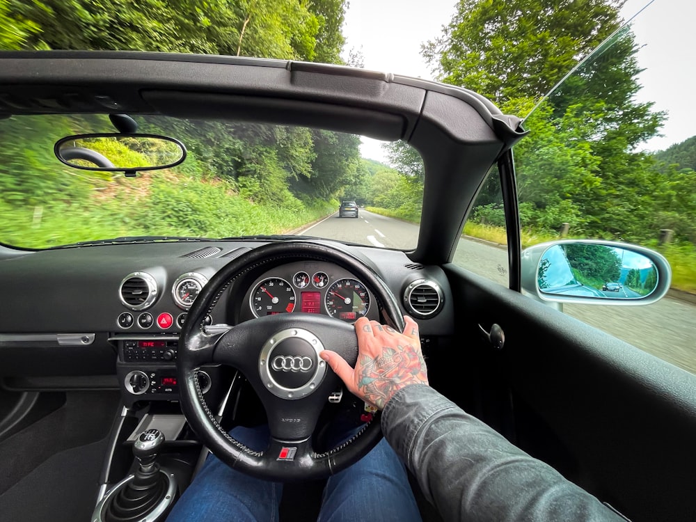 person in blue denim jeans driving car