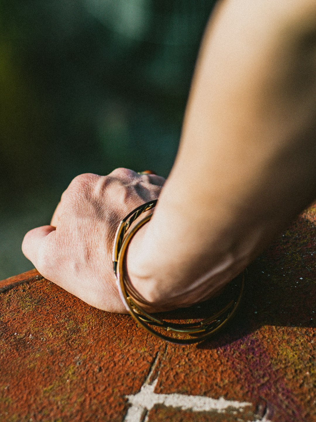 person wearing gold ring on brown sand