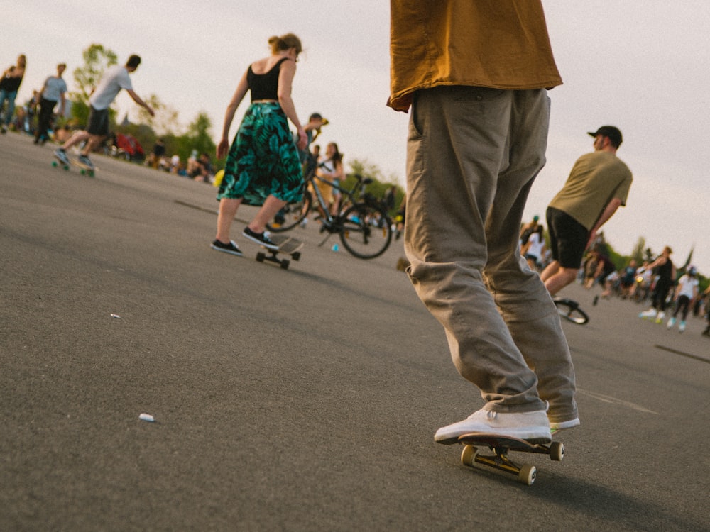 man in brown pants and woman in blue and white floral dress riding on bicycle during