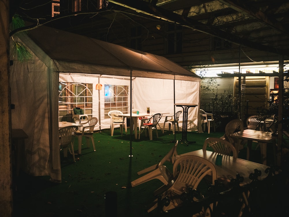 white plastic chairs and table in white tent