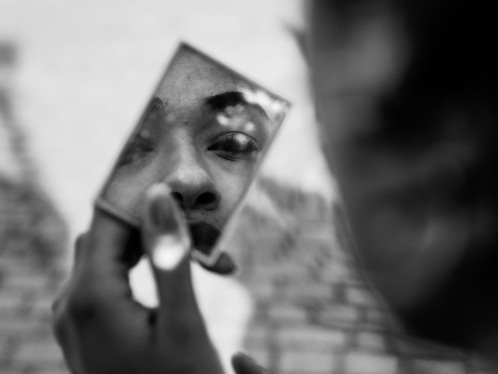 grayscale photo of person holding photo