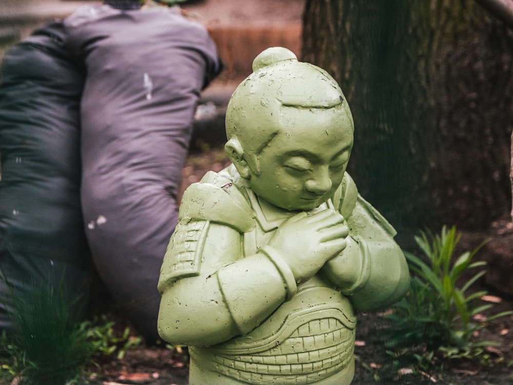 green concrete statue of a baby