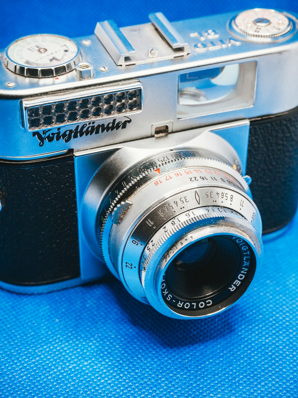 black and silver camera on blue textile