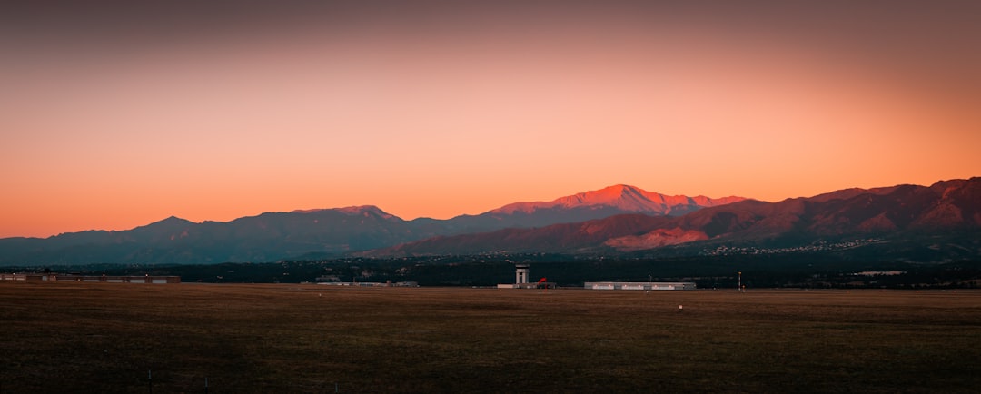 white and red house on brown field during sunset