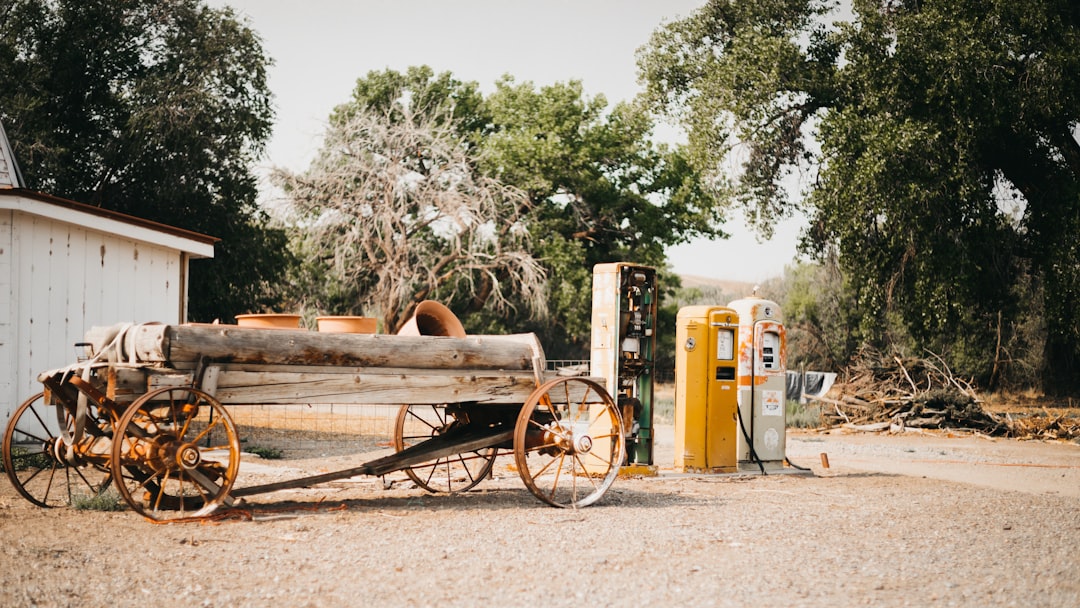 brown wooden cart on brown dirt road during daytime