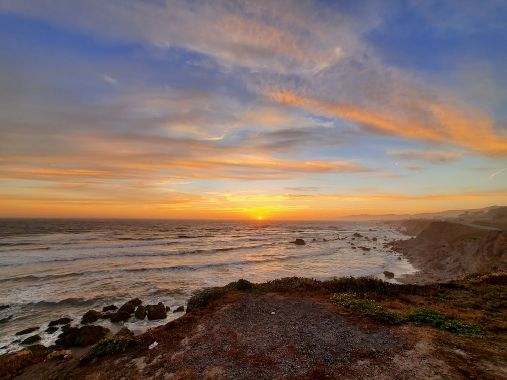 body of water under blue sky during sunset