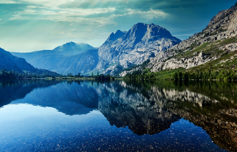 lake near mountain under blue sky during daytime