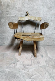 A rustic leather accent chair with sturdy wooden frame and nailhead trim.