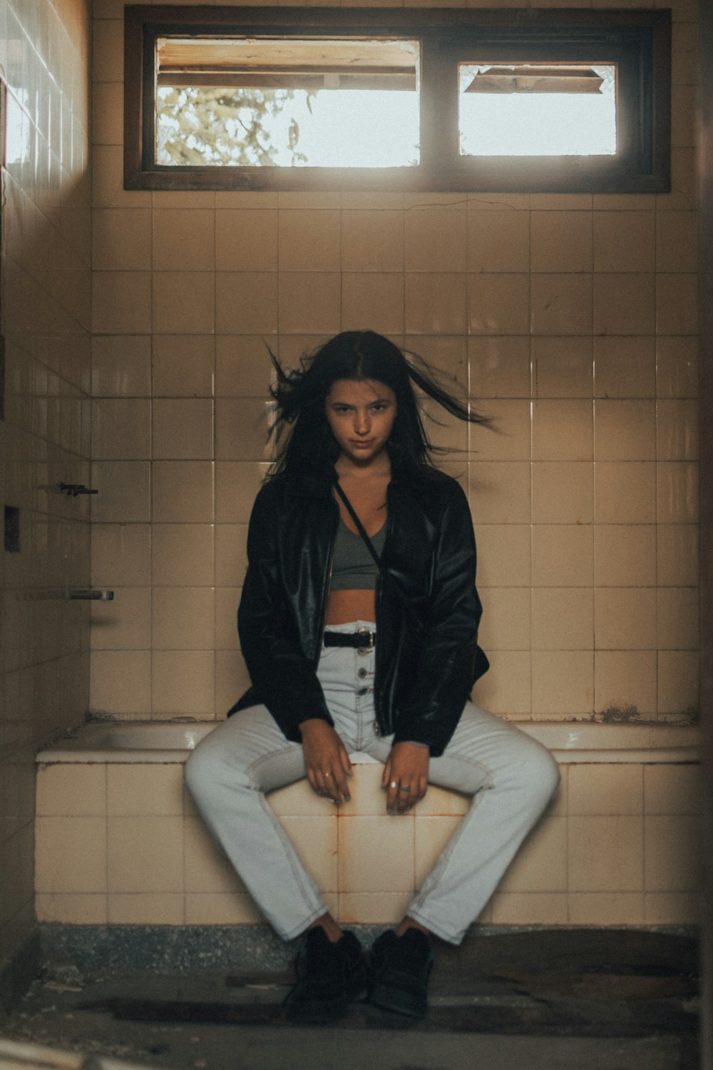 woman in black jacket sitting on white ceramic bathtub