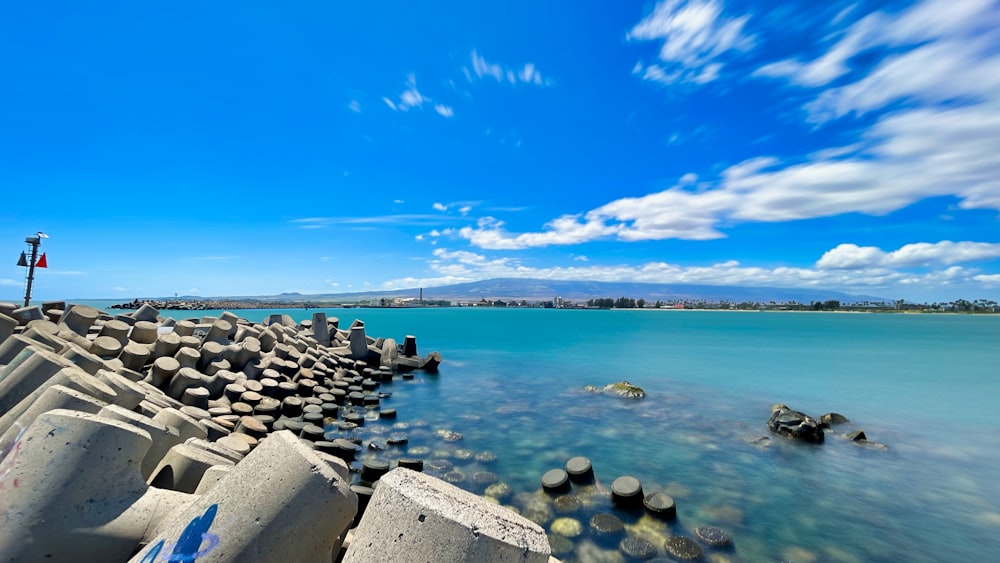rocas grises en la orilla del mar bajo el cielo azul durante el día