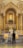 A couple in wedding attire is kneeling before an ornate and gilded church altar. The altar is adorned with white flowers, tall candles, and a central religious icon. The architecture features intricate details and gold accents, showcasing a blend of classical and religious elements.