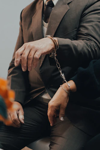 man in black suit jacket wearing silver chain bracelet