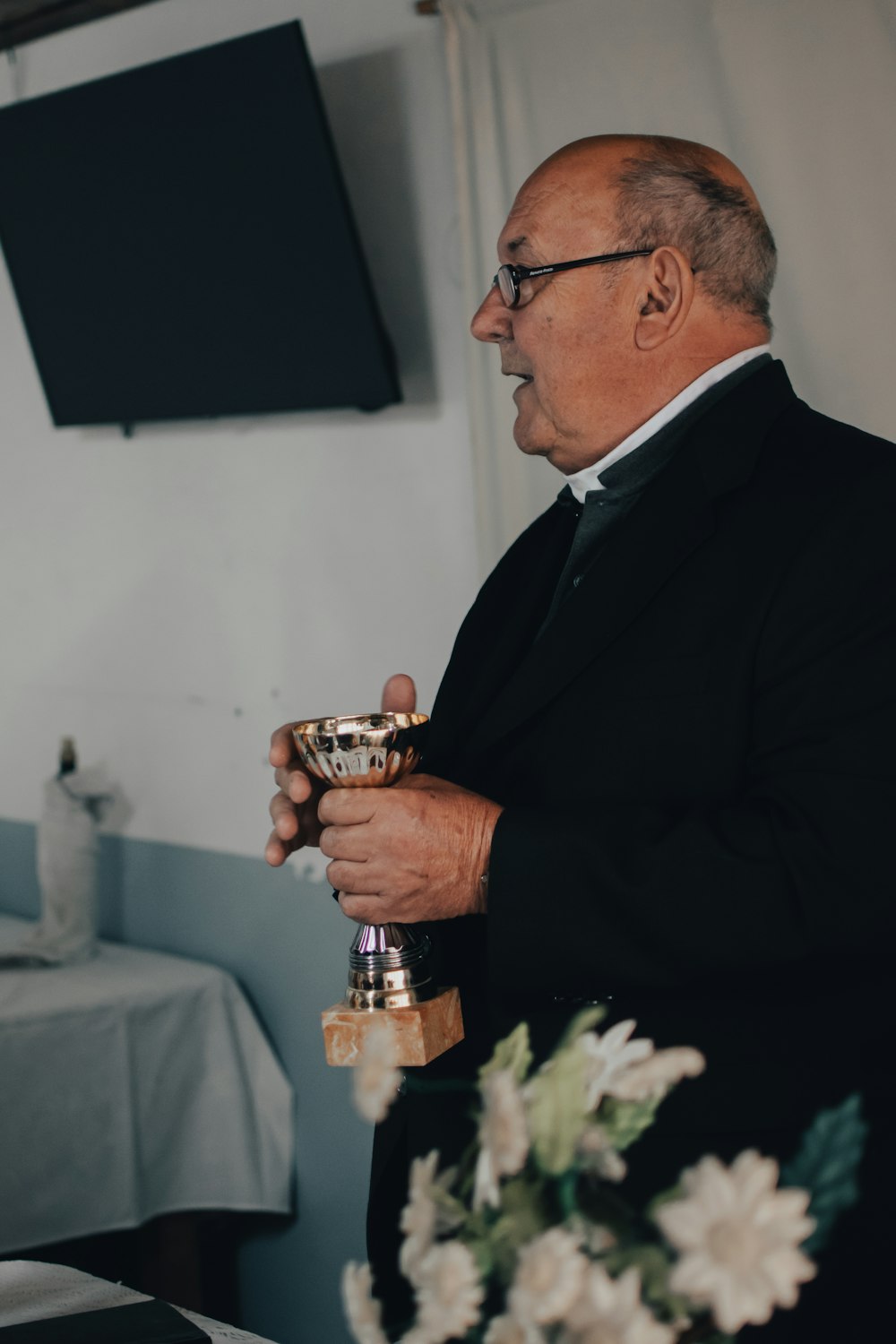 man in black suit holding silver trophy