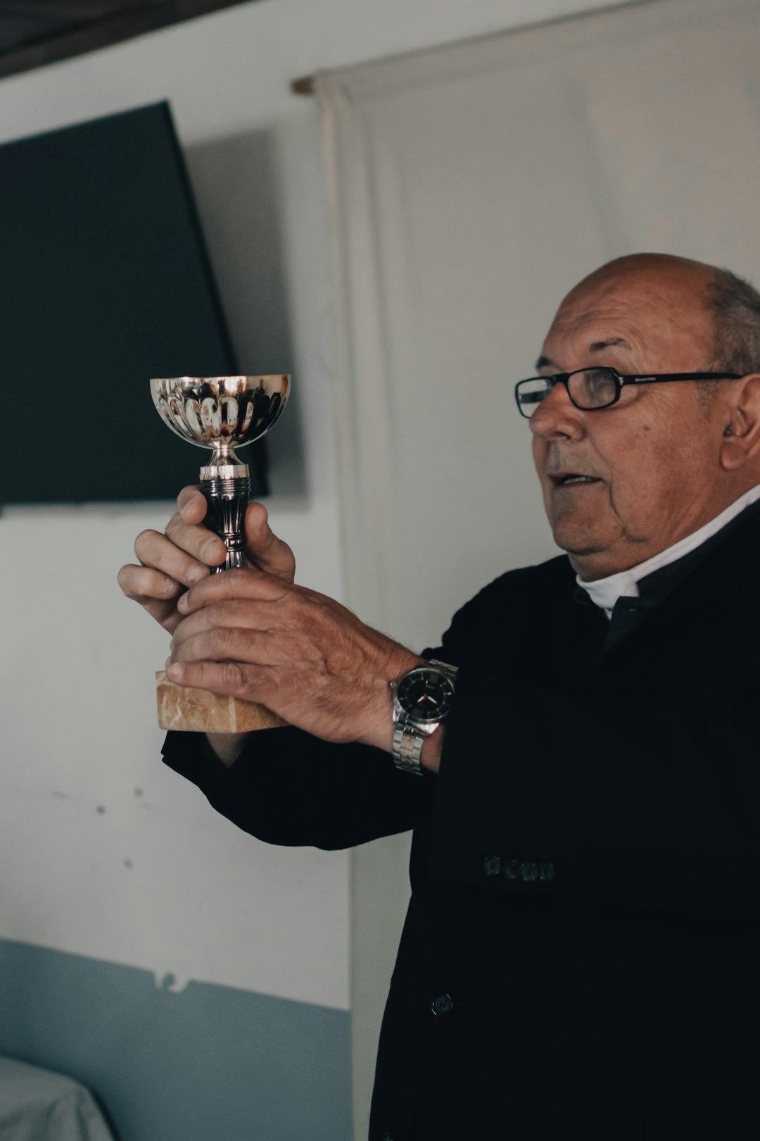man in black sweater holding trophy