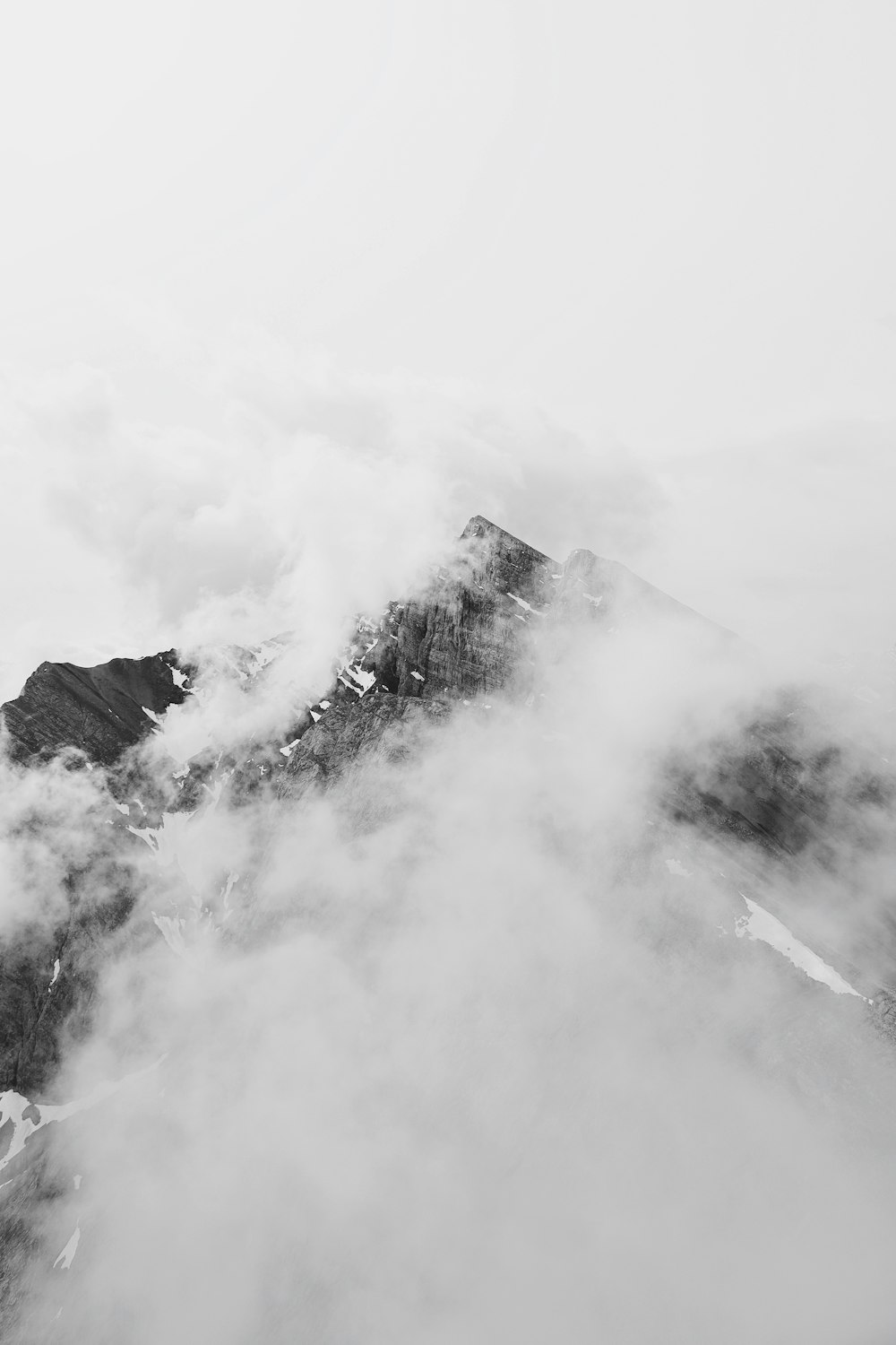 雲に覆われた山のグレースケール写真