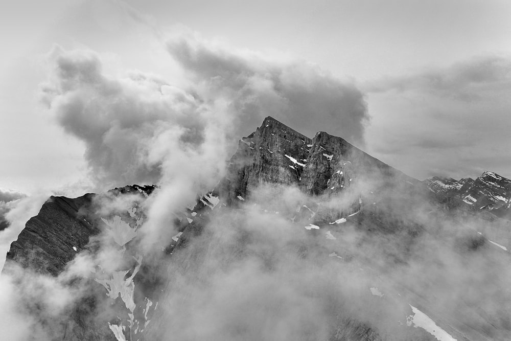 grayscale photo of mountain covered with clouds